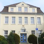 Das dreigeschossige Gebäude der Musikschule trägt über dem alten Eingang das Wappen der Stadt Aurich.
