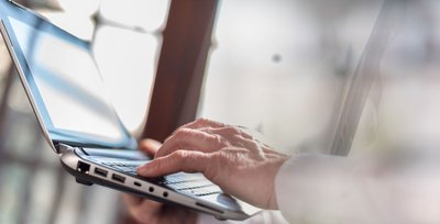 Eine Person bedient einen Laptop 