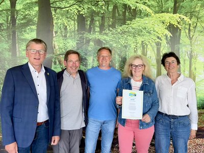 Bürgermeister und Vertreter der Steuerungsgruppe Fairtrade zeigen die erneuerte Urkunde der Fairtrade Towns 