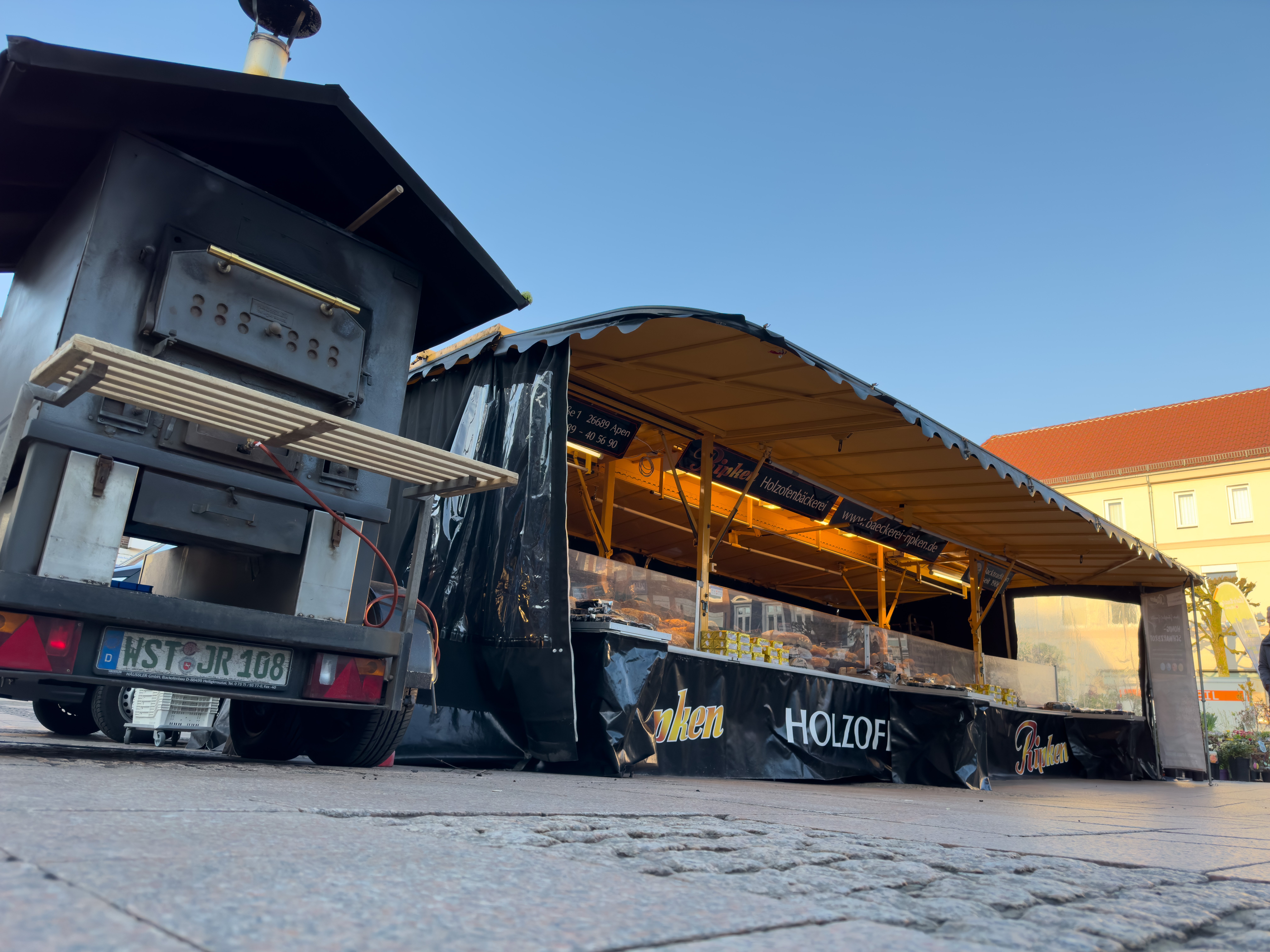 Holzofen und Verkaufswagen mit Backwaren