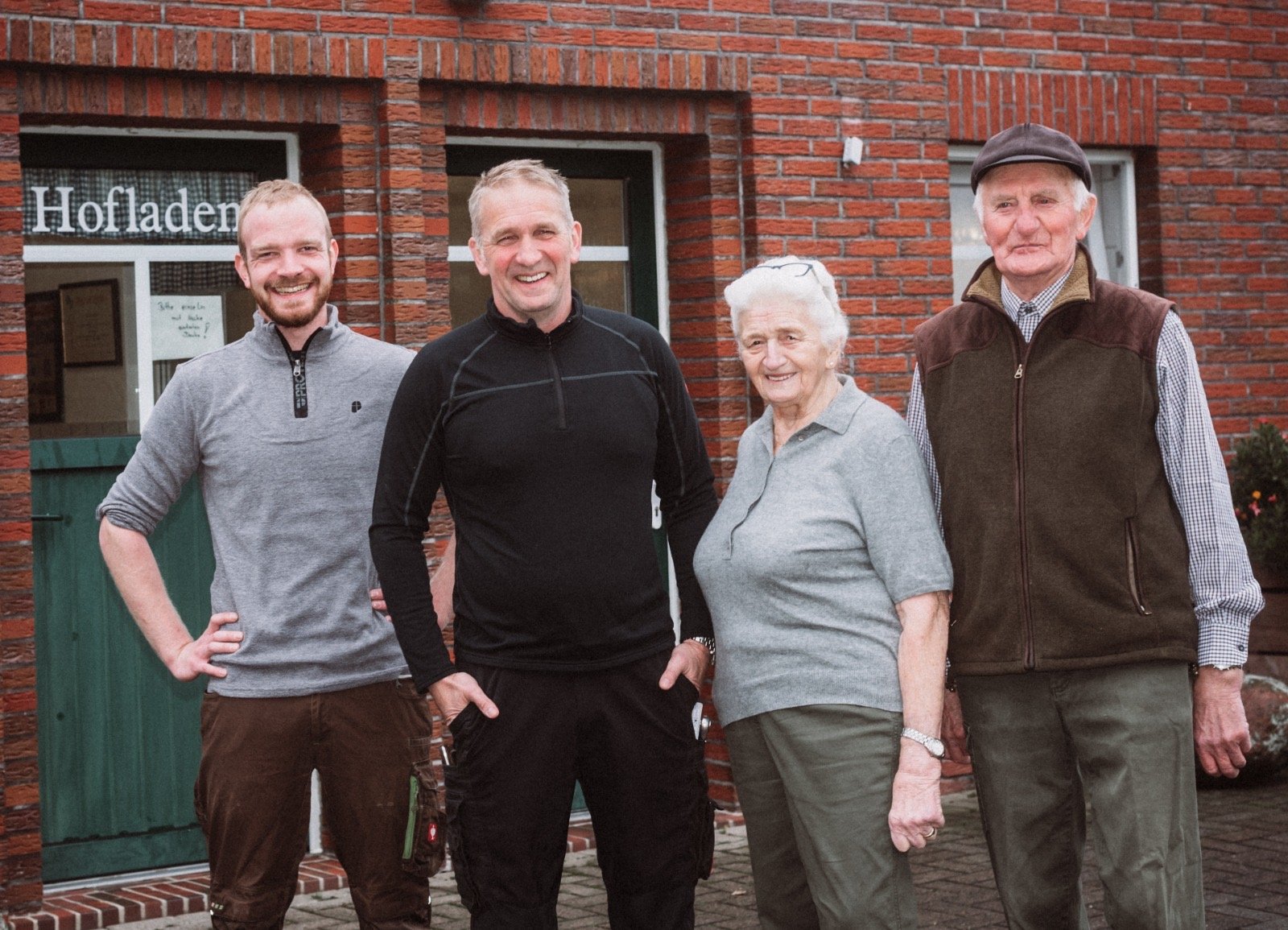 vier Personen stehen vor einem Betriebsgebäude 