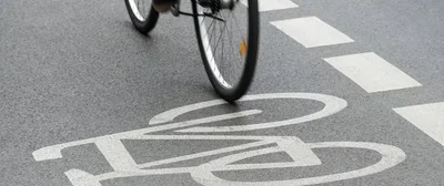 Eine Person auf einem Fahrrad befährt einen Fahrradweg