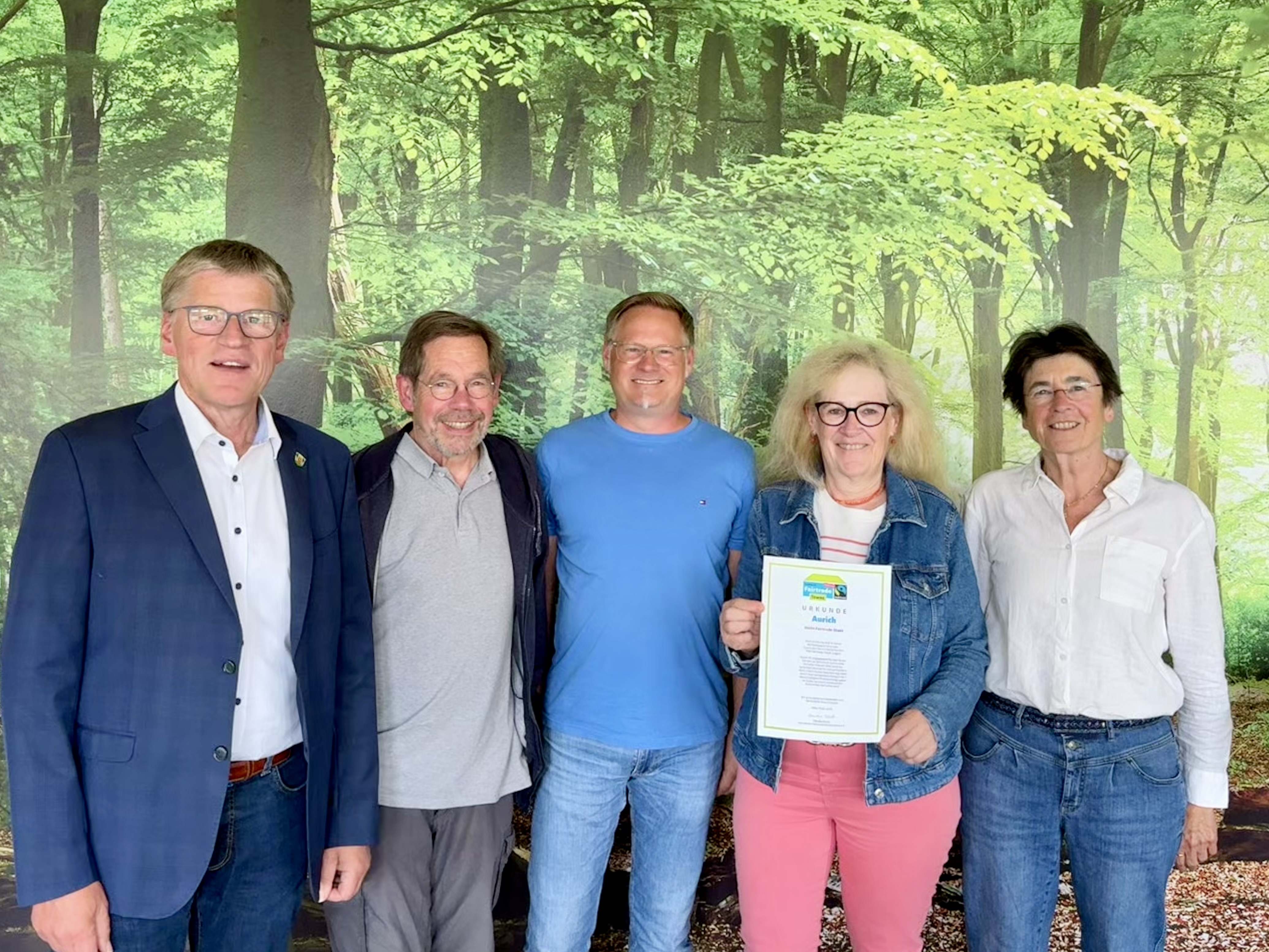 Bürgermeister und Vertreter der Steuerungsgruppe Fairtrade zeigen die erneuerte Urkunde der Fairtrade Towns 