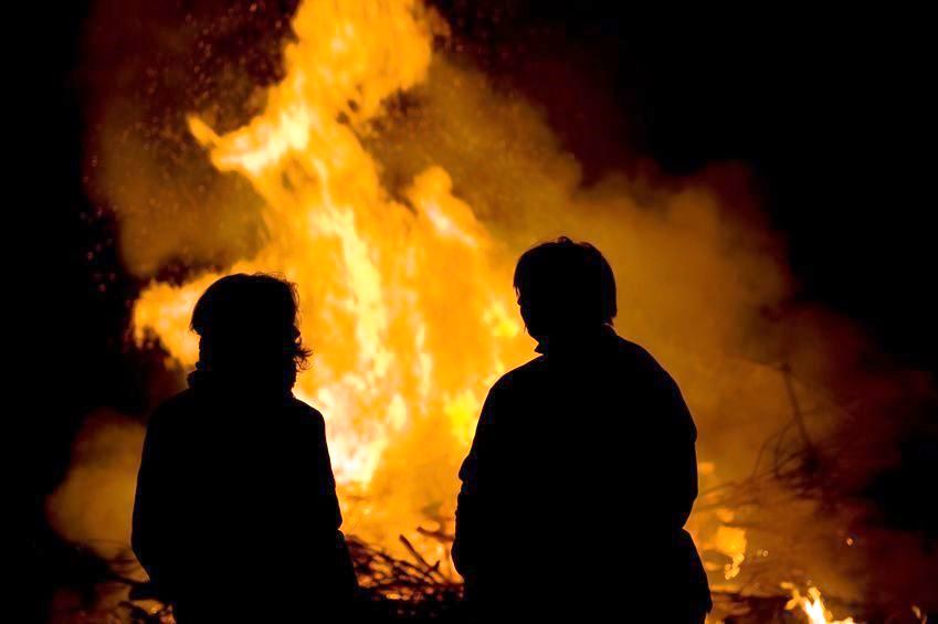 Zwei Personen halten sich vor einem Brauchtumsfeuer auf 