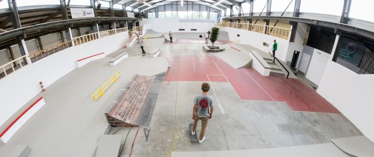 Personen auf Skateboards fahren durch die Skatehalle