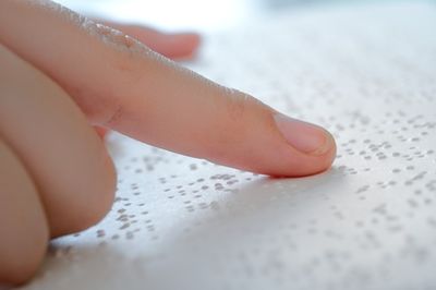 Eine Person liest einen Text in der Brailleschrift