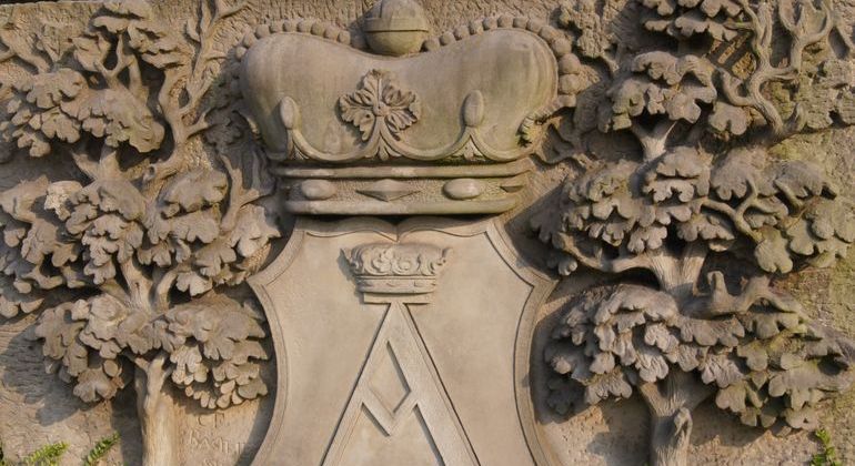 Der Wappenstein vor dem Rathaus. Das Wappen der Stadt zeigt zwischen zwei Bäumen einen gekrönten Schild. Darin ein gotisches großes A. 