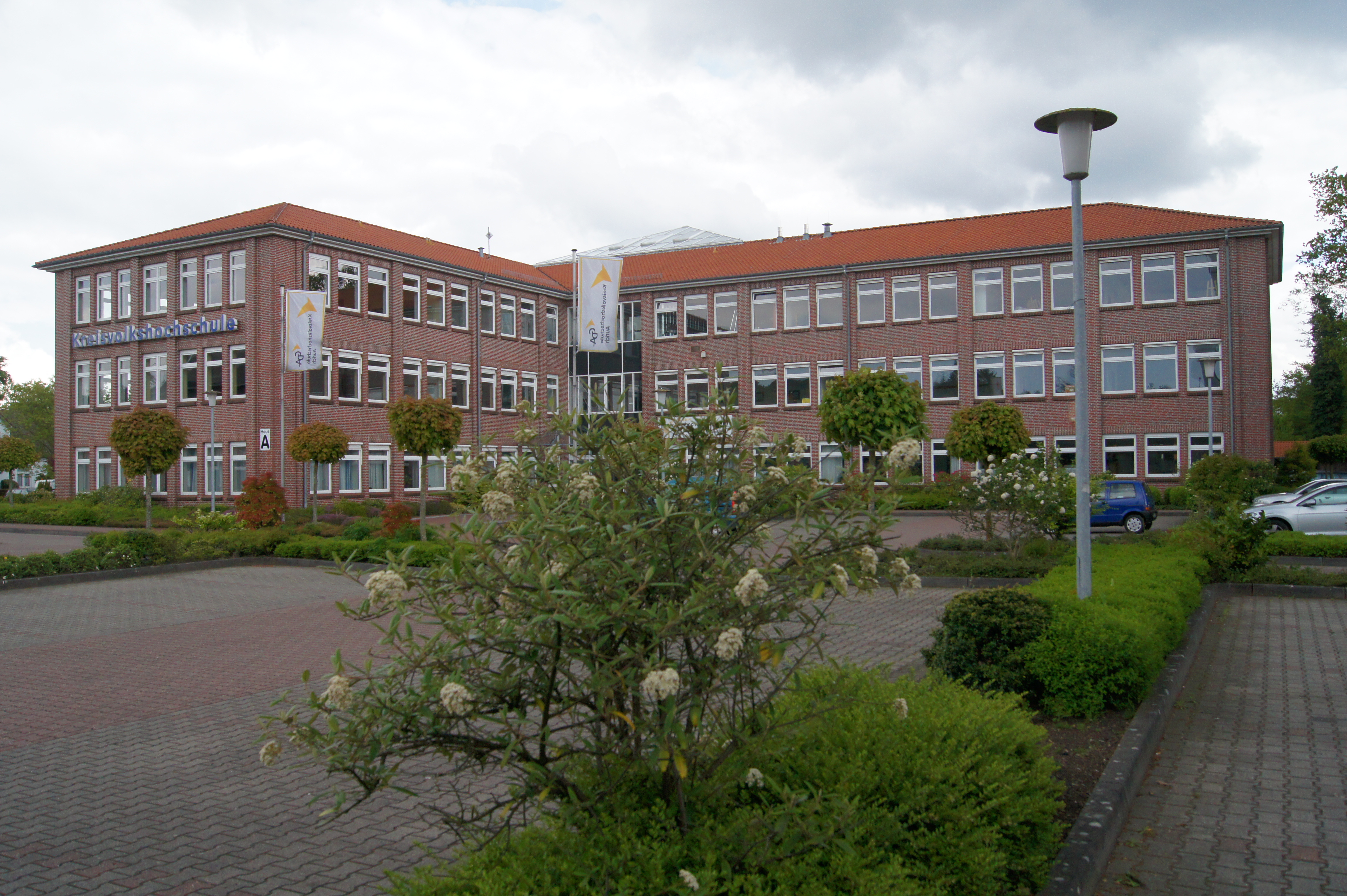 Die Kreisvolkshochschule Aurich. Im Vordergrund die Parkplätze. 