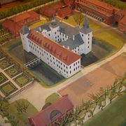 Das Modell der Wasserburg steht im Historischen Museum. Das Modell hat einen weißen Anstrich, mehrere Stockwerke und einen Innenhof. 