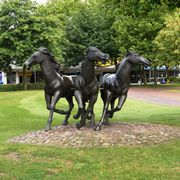 Skulptur mit drei braunen Pferden in Lebensgröße. Sie steht an der Kreuzung Am Pferdemarkt. 