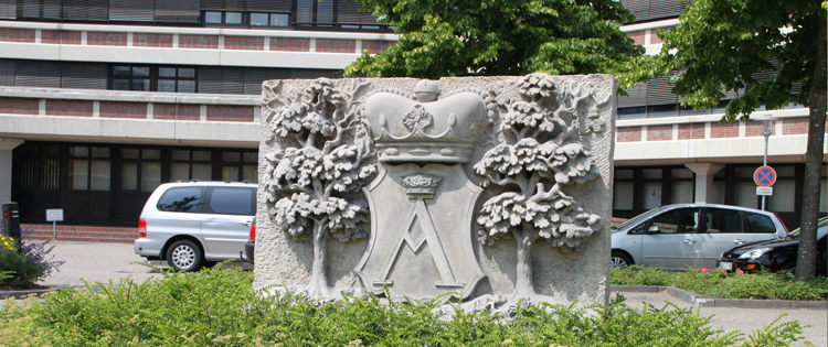 Das Rathaus Aurich mit dem Wappenstein im Vordergrund 